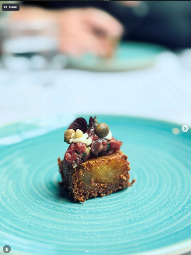 A crisp plated square with a colourful garnish on a turquoise plate